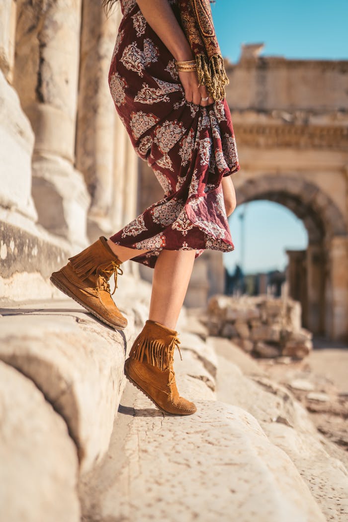 A woman walking through ancient ruins in Ephesus, Turkey wearing a boho outfit.